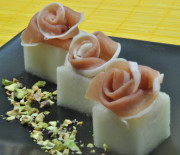 Cubos de melón con rosas de jamón en el centro